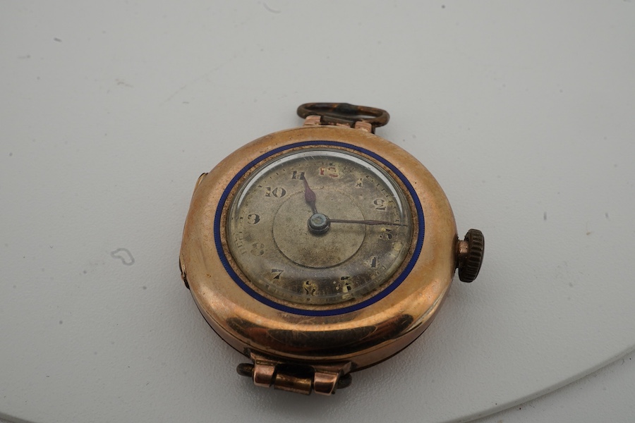 A lady's George V 9ct gold and enamel manual wind wrist watch, no strap, together with an unmounted oval cut quartz, carved with monogram, 19mm by 16mm.